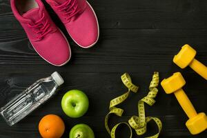 Workout plan with fitness food and equipment on dark background, top view photo