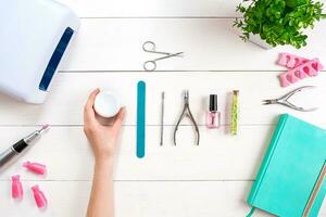 Woman Hands Care. Top View Of Beautiful Smooth Woman's Hands With Professional Nail Care Tools For Manicure On White Background. photo