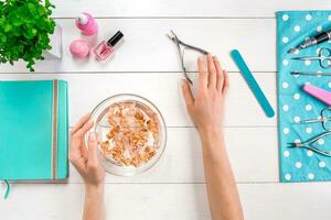 Beautiful woman's hands with perfect manicure in bowl of water photo