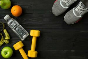 Workout plan with fitness food and equipment on dark background, top view photo