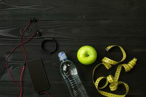 Athlete's set with bottle of water on dark background photo