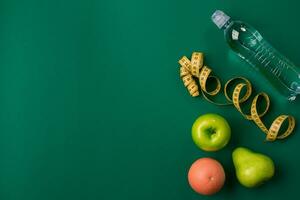 Workout plan with fitness food and equipment on green background, top view photo