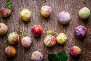 Fresh juicy plums on a wooden background photo