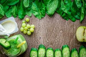 verde zalamero con manzanas, yogur, espinaca, Pepino en de madera antecedentes foto