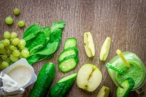 verde zalamero con manzanas, yogur, espinaca, Pepino en de madera antecedentes foto