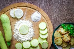 Healthy eating, vegetarian food. Raw zucchini prepared for frying in a frying pan with spices in olive oil photo