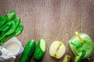 verde zalamero con manzanas, yogur, espinaca, Pepino en de madera antecedentes foto