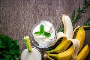 Ice cream with fresh banana and mint on wooden table. photo