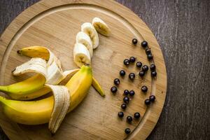 Currants and fresh banana on wooden table. photo