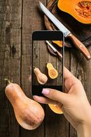 un joven mujer tomando foto de comida en teléfono inteligente, fotografiando comida con móvil cámara