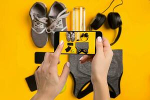 Sport equipment photographing on mobile phone. Smartphone screen with fitness tools image photo