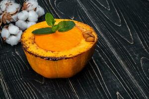 sano natural alimento, calabaza crema sopa en un negro de madera antecedentes foto