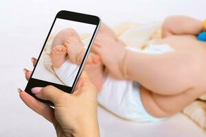 Photographing baby concept - feet of a six months old baby wearing diapers photo