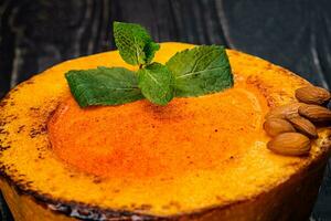 Healthy natural food, pumpkin cream soup on a black wooden background photo