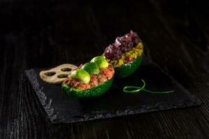 Salmon tartare and avocado salad on a black background photo