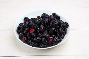 mulberry in white plate, top view photo