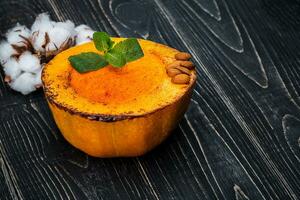 Healthy natural food, pumpkin cream soup on a black wooden background photo