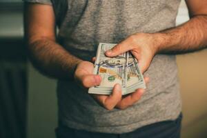 A man holds dollars in his hands photo