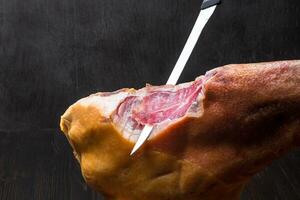 Jamon. Jamon serrano. Traditional Spanish ham on black close up. photo