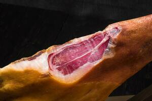 Jamon. Jamon serrano. Traditional Spanish ham on black close up. photo