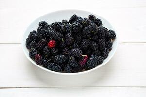 mulberry in white plate, top view photo