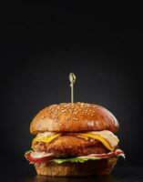 hamburguesa fresca y sabrosa sobre fondo negro foto
