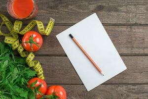 Glass of tomato juice with vegetables and measuring tape on table close-up photo