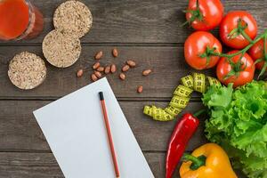 Glass of tomato juice with vegetables and measuring tape on table close-up photo