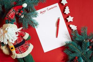 Red pen and notepad on red table decorated with a fir branch. The background for the text. photo