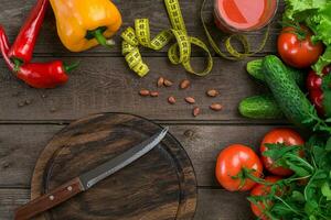 Glass of tomato juice with vegetables and measuring tape on table close-up photo