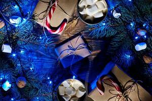 Christmas hot drink. Cocoa with marshmallow, garland and spruce branches on a wooden background. Top view photo