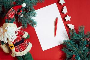 Red pen and notepad on red table decorated with a fir branch. The background for the text. photo