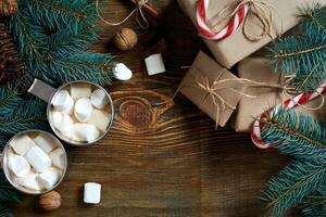 Cocoa with marshmallow, chocolate and spruce branches on a wooden background photo