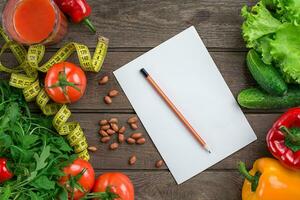 Glass of tomato juice with vegetables and measuring tape on table close-up photo