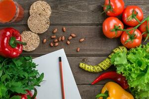 Glass of tomato juice with vegetables and measuring tape on table close-up photo