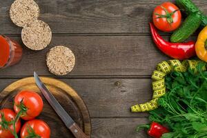 Glass of tomato juice with vegetables and measuring tape on table close-up photo