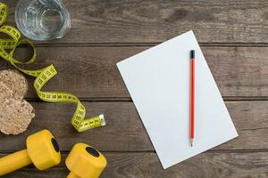 Glass of water with vegetables and measuring tape on table close-up photo