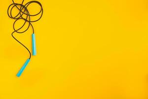 Top view of Skipping rope on yellow background photo
