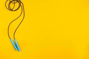 Top view of Skipping rope on yellow background photo