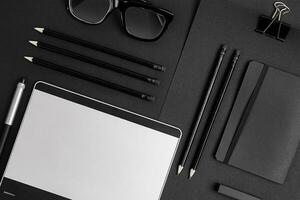 Blank notepad with clips, pens and glasses flat lay. photo