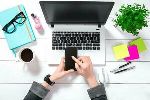 Laptop with blank screen and girl's hands. Flat lay, top view workspace photo