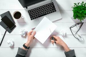 High angle view of an young woman working at her office desk with documents and laptop. photo