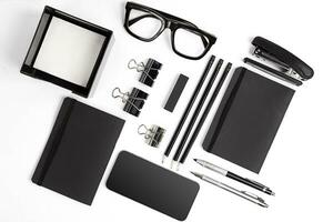 Blank notepad with clips, pens and glasses flat lay. photo