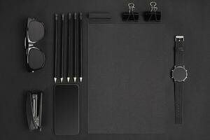 Blank notepad with clips, pens and glasses flat lay. photo