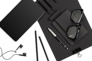 Blank notepad with clips, pens and glasses flat lay. photo