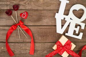 Box with red ribbon and ring on a wooden background, Valentine's Day concept photo