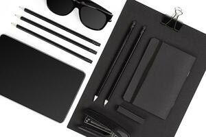 Blank notepad with clips, pens and glasses flat lay. photo