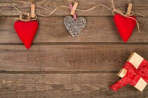 Valentine background of gift box and hearts on wood. Space for copy. photo