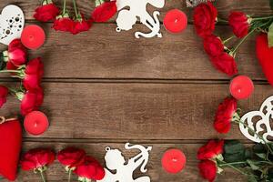 Red roses, candles and hearts over wood with copy space. Valentines day background photo