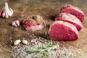 Juicy raw beef steak on wooden table photo